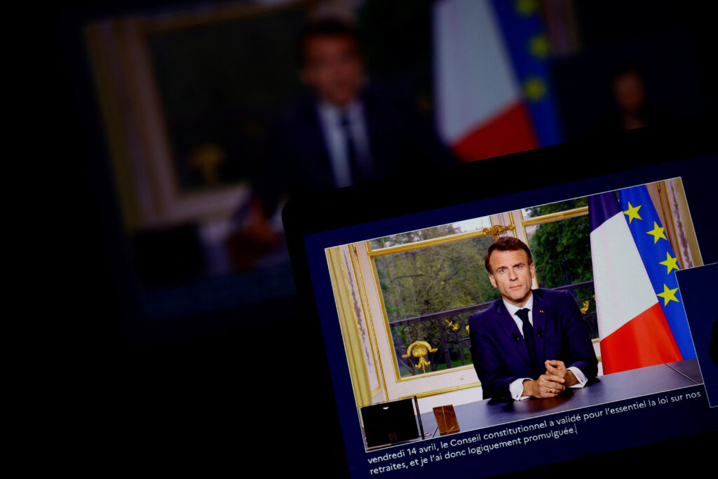 French President Emmanuel Macron appears on a screen, as he speaks during a special address to the nation from the Elysee Palace, after he signed into law the pension reform raising the retirement age, in Paris, France, April 17, 2023. REUTERS/Sarah Meyssonnier