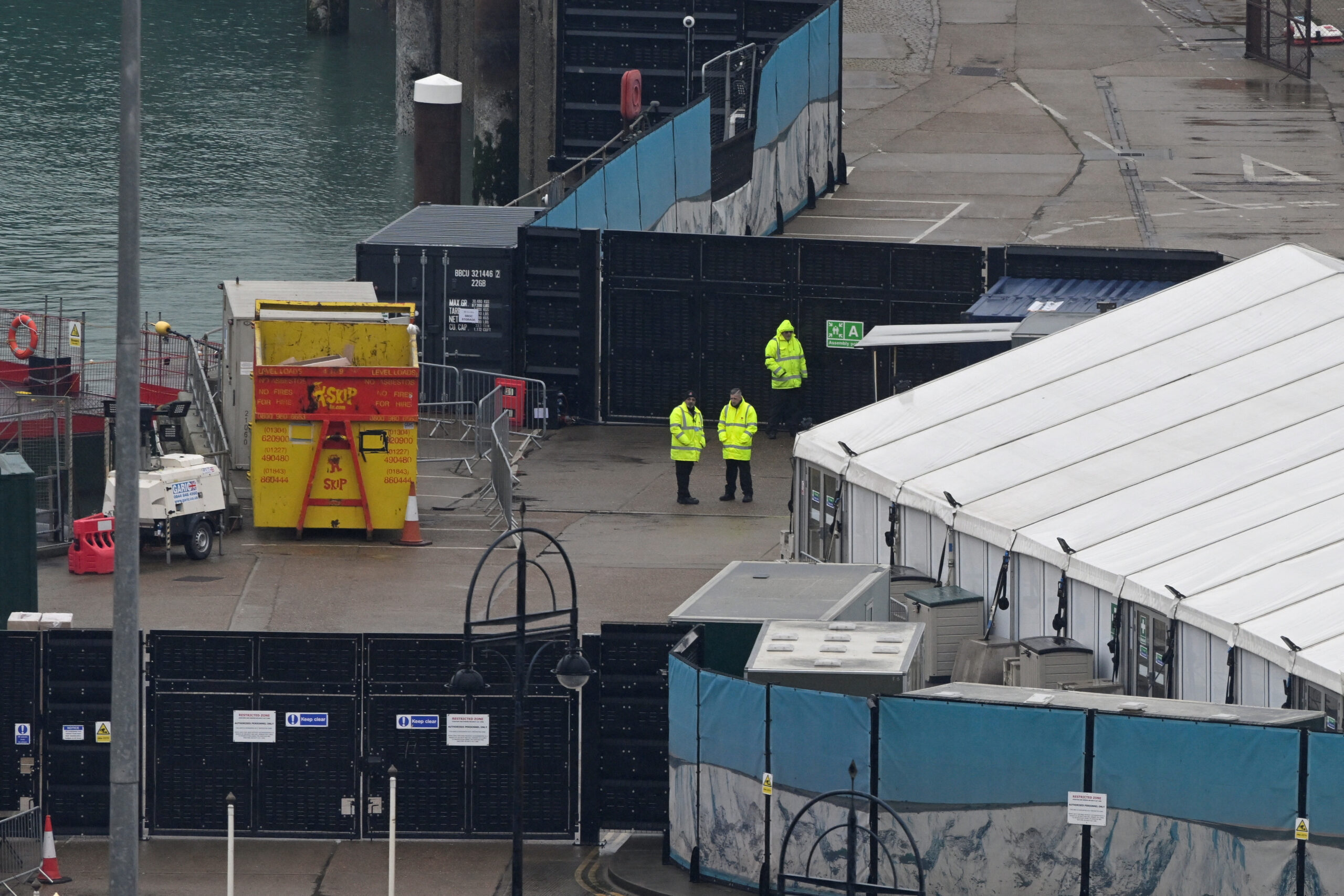 Officials stand beside a migrant processing centre at the Port of Dover, in Dover, Britain. REUTERS/Toby Melville