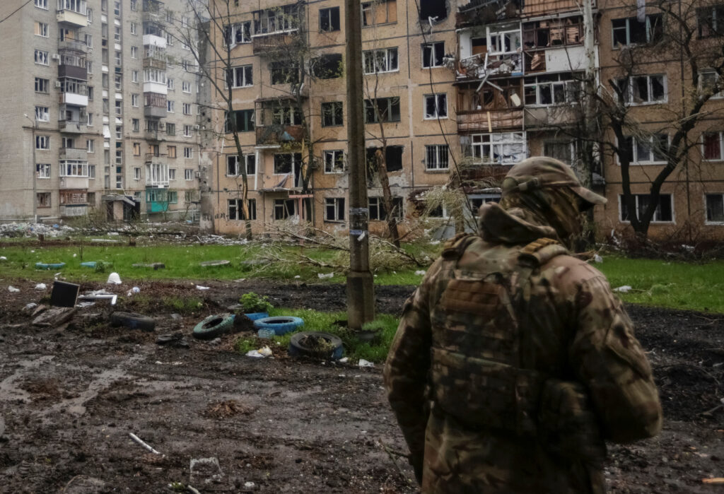 A Ukrainian service member walks near residential buildings damaged by a Russian military strike, amid Russia's attack on Ukraine, in the front line town of Bakhmut, in Donetsk region, Ukraine. REUTERS/Anna Kudriavtseva