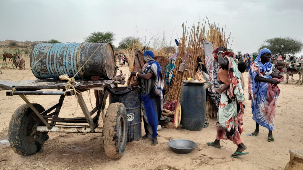 A Sudanese woman, who fled the violence in her country, tries to get water from a barrel near the border between Sudan and Chad in Adre, Chad April 26, 2023. REUTERS/Mahamet Ramdane