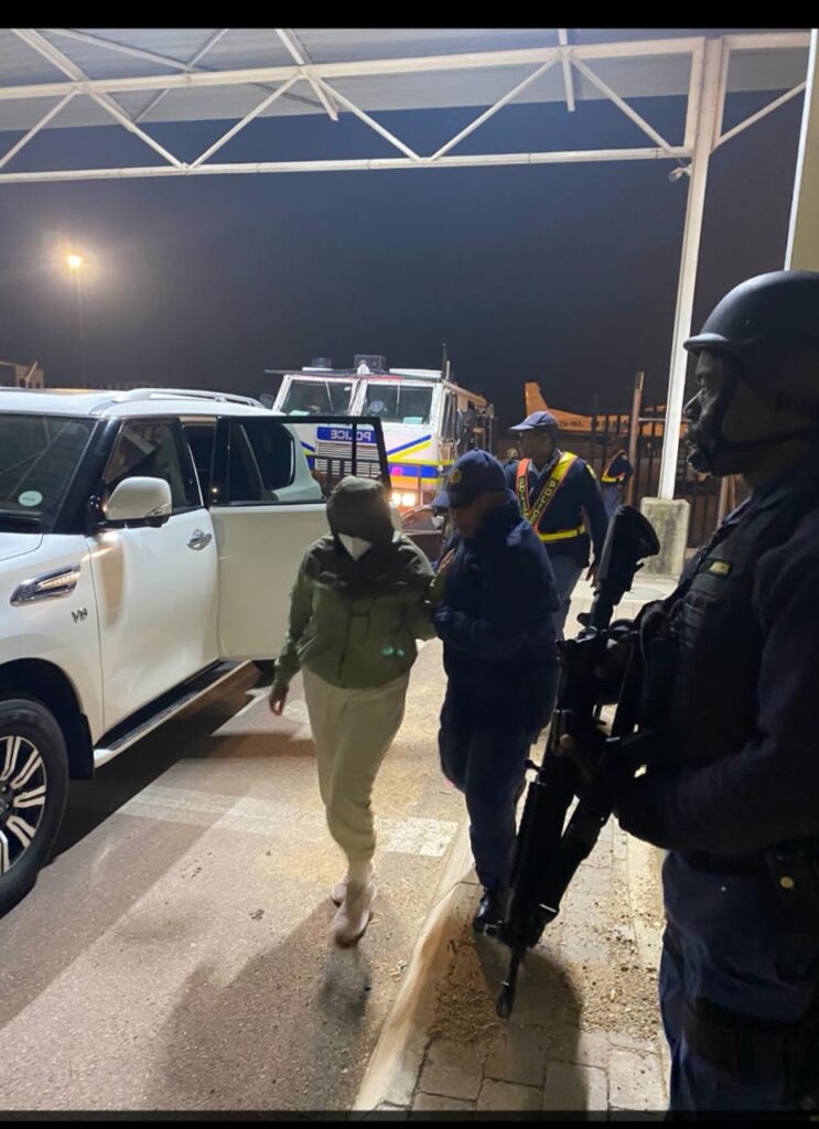 Police guarding the two love birds after arriving in South Africa.