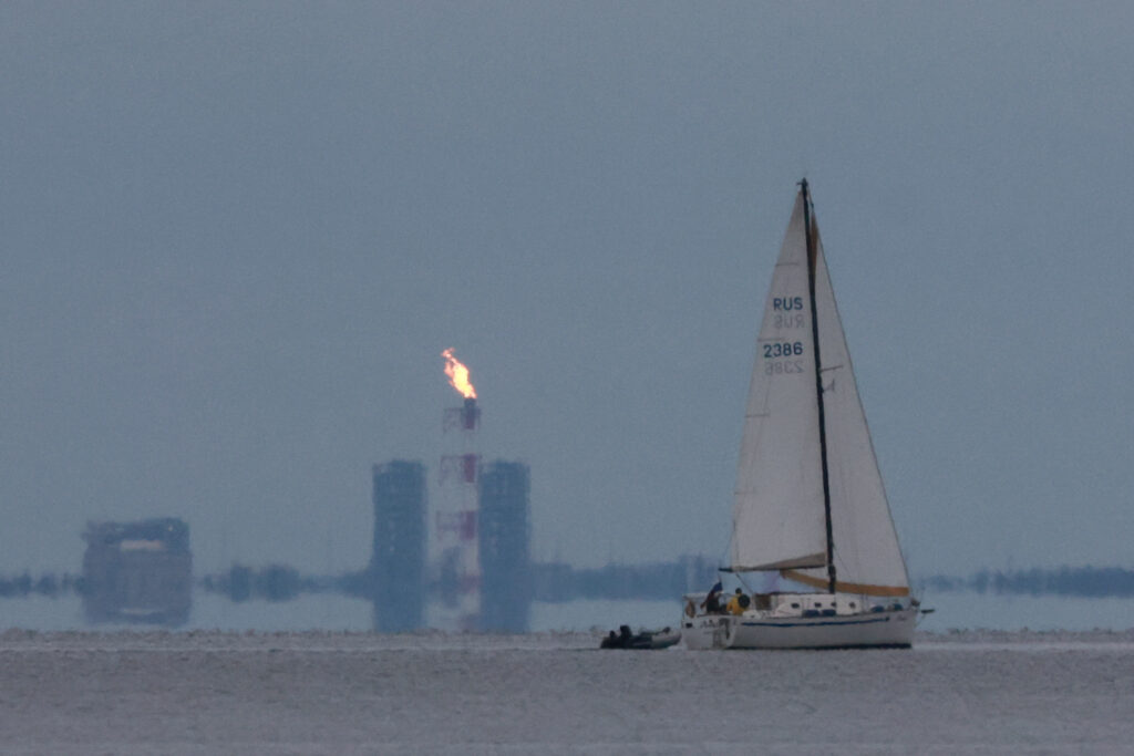 A yacht sails past a gas flare at Portovaya Bay on the coast of the Gulf of Finland in the Leningrad Region, Russia. REUTERS/Stringer