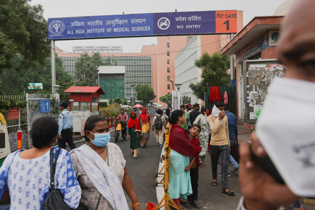 People walk across the road outside All India Institute of Medical Sciences (AIIMS) in New Delhi. REUTERS/Anushree Fadnavis