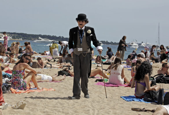 FILE PHOTO: A man dressed as Charlie Chaplin walks on the beach in Cannes during the 65th Cannes Film Festival May 17, 2012. REUTERS/Eric Gaillard